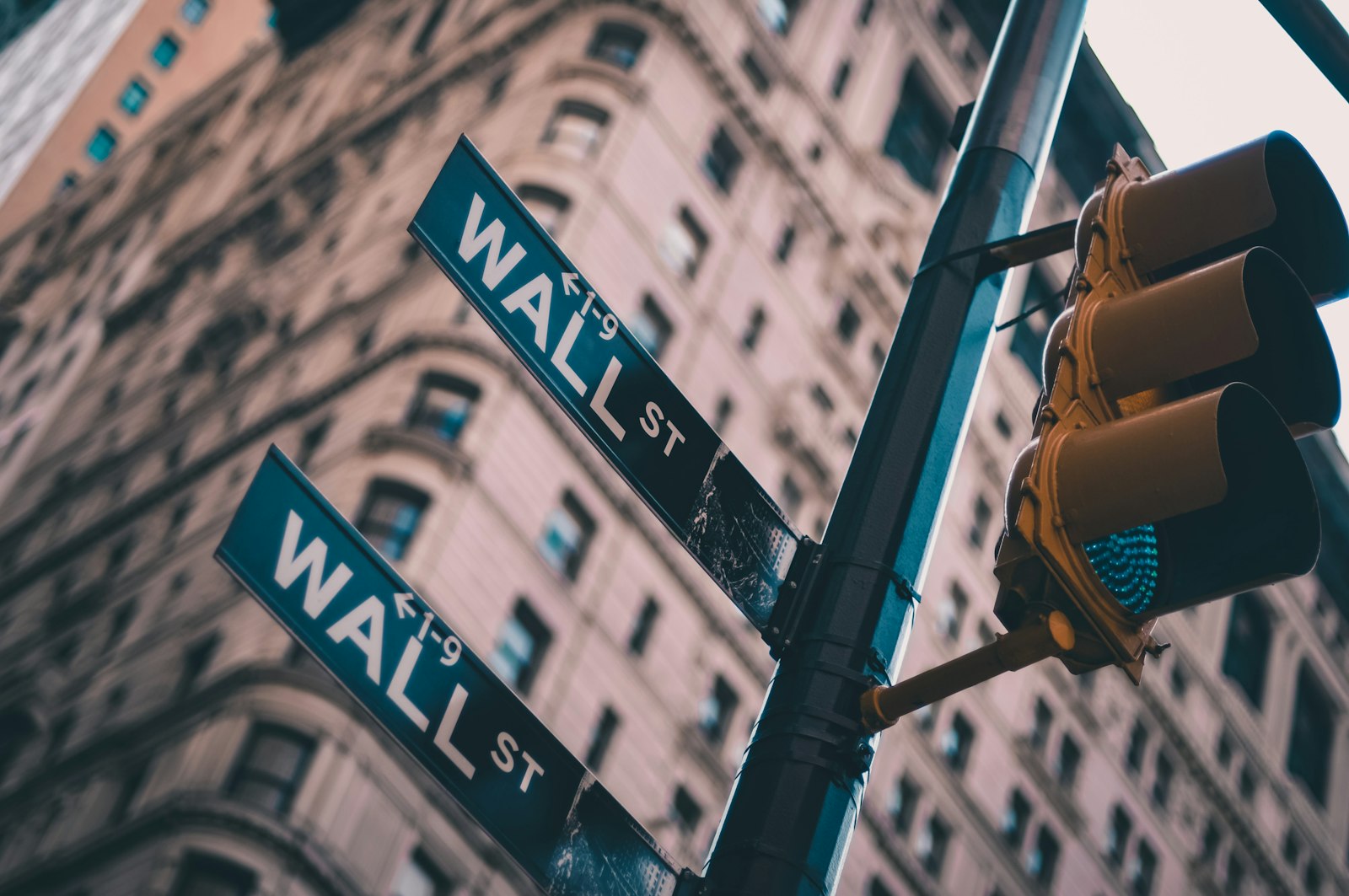 A Wall Street street sign at the corner of a Manhattan intersection